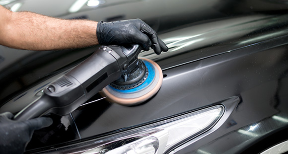 a person using a polisher on a car to buff out scratches and blemishes