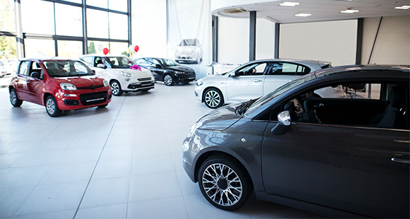 a number of different shiny cars in a showroom