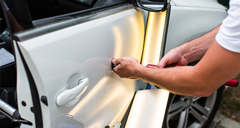 a SMART repairer using a tool to perform a paintless dent repair
